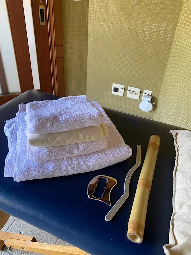 Toalhas dobradas, bambus e ferramentas de madeira sobre a maca